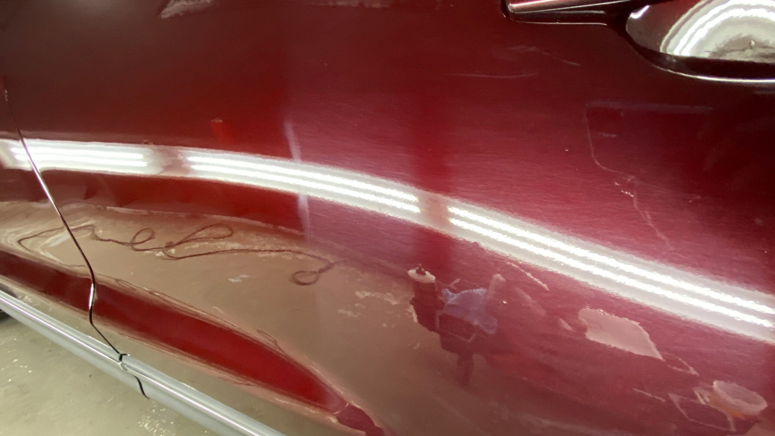 Paint defects and swirls visible under correction lighting