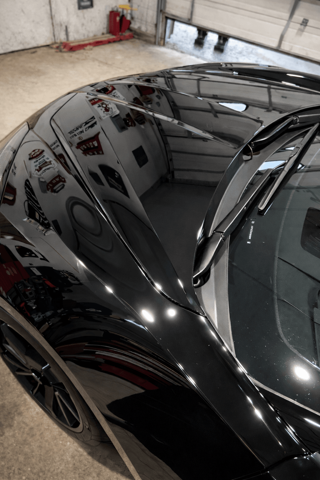 Black sports car with deep reflections after ceramic coating and detailing