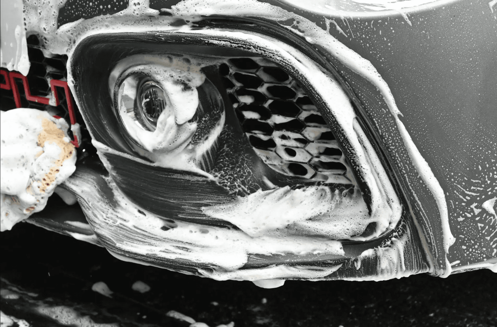 Detailed headlight being cleaned with foam