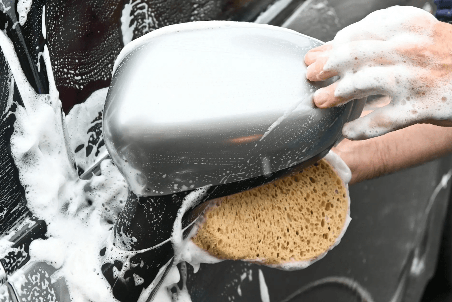 Hand washing side mirror during premium detailing